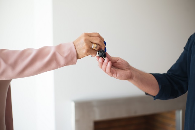 Woman Giving Key To House Sitter